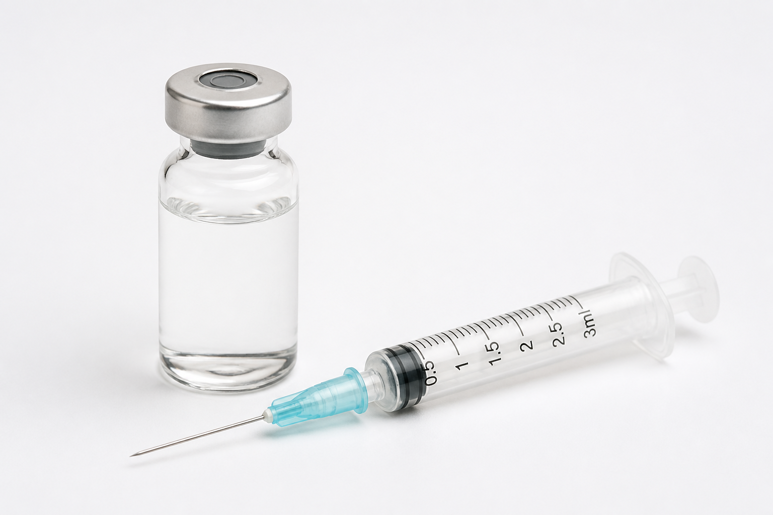 A single glass medicine vial with a metal cap beside a clean syringe on a plain white surface
